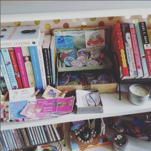 feminist button and books collection on a shelf in the L Spot shop