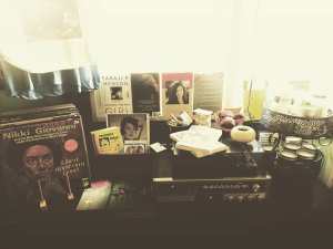 album stack with nikki giovanni like a ripple on a pond album in front, taraji p henson Girl book, a vintage stereo with soap, palo santo sticks, hand made candles and zines