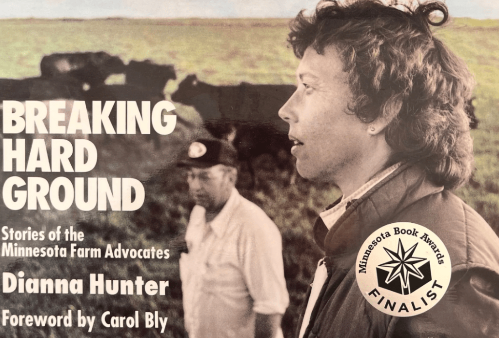 White woman and White man in front of black cows on green grass
